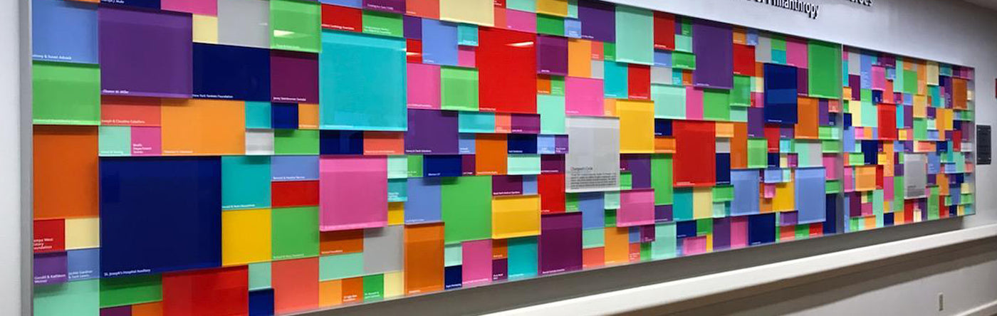 Colorful square pattern of donor blocks on a wall with a light colored wall