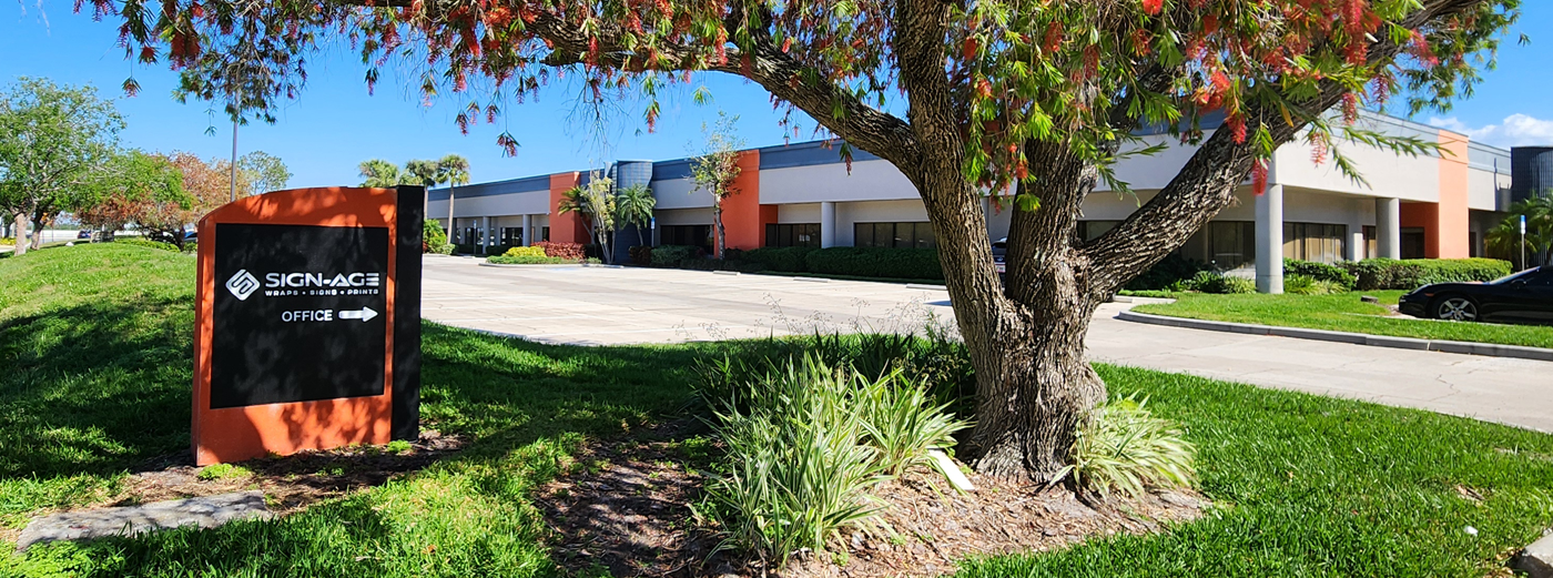 Sign-Age, Clearwater building with a sign in front, surrounded by trees and grass