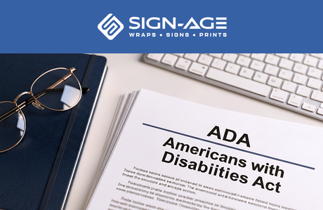 A document with the text "ADA Americans with Disabilities Act" on a desk with a keyboard and pair of glasses, with the Sign-Age logo on top.
