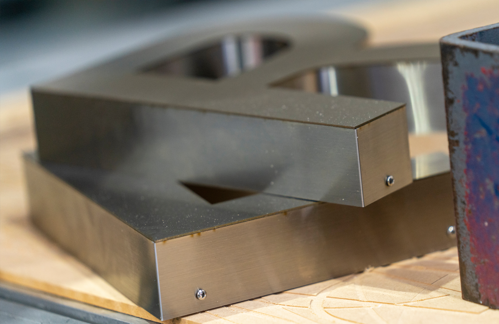 A closeup of stacked metal letters on a work table.
