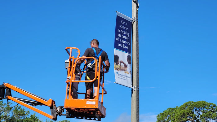 Pole Banner being installed with equipment in tampa, FL