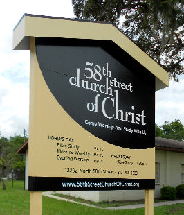 Directional post and panel sign for 58th Street Church of Christ with contact information and services listed.