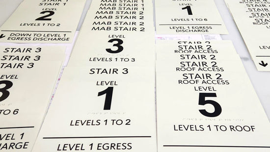 Set of ADA floor number signs for different levels and staircases, with text in tactile letters and Braille.