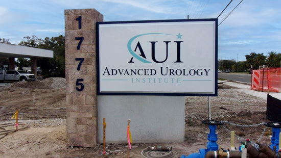 AUI Advanced Urology Institute illuminated pan face monument sign with construction visible in the background