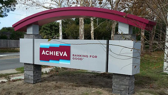 Achieva monument sign with a red arch in an outdoor setting