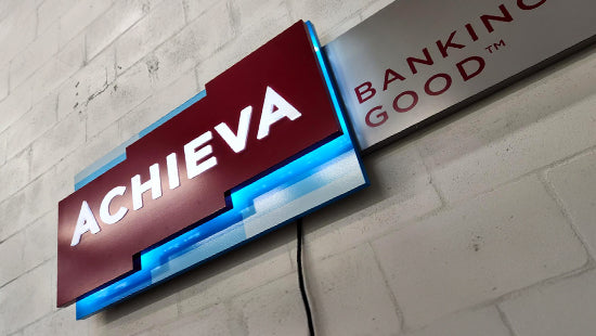 Achieva Banking for Good illuminated dimensional sign on a block wall