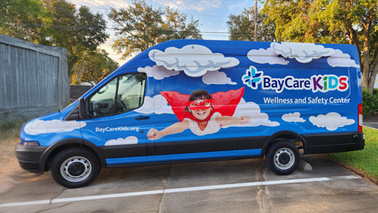 Van with BayCare Kids branding and a superhero graphic on a full vehicle wrap.
