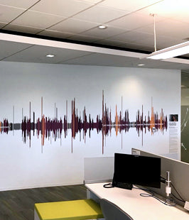 Modern office interior with a wall mural with a sound wave design on the wall.