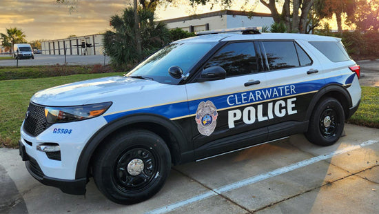 Clearwater Police SUV with partial vehicle wrap parked in a parking space with a building and trees in the background.