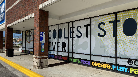 Storefront with colorful graffiti-style text on a window graphic