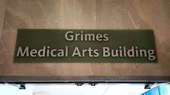 Dimensional Plaque for Grimes Medical Arts Building on a stone wall above a doorway