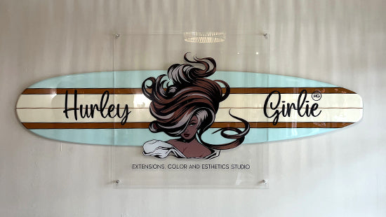 Decorative acrylic sign with a hair extension design and 'Hurley Girlie' text on a light blue background.