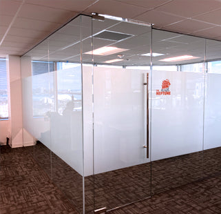 Glass office partition with privacy film and a logo