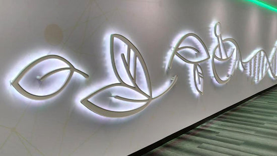 Illuminated halo lit dimensional sign with leaf design on a light background