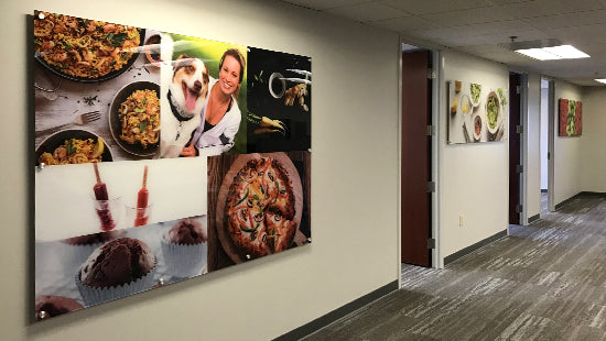 Wall with large framed photo collage posters of food and a dog, in an office setting.