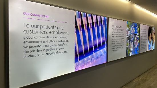 Wall with large display panels featuring text and images on a light background