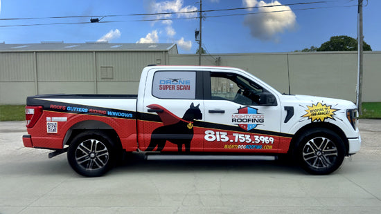 Mighty Dog Roofing vehicle wrap on a white truck, parked in a lot.