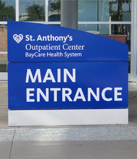 Blue illuminated monument sign for St. Anthony's Outpatient Center with 'Main Entrance' text.