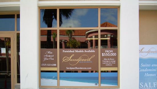 Real estate office window graphic with Sandpearl Residences advertisement