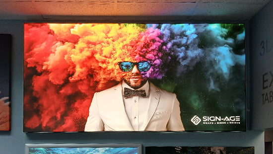 Lightbox print of a man in a suit with colorful smoke effects, and the 'SIGN-AGE' logo.