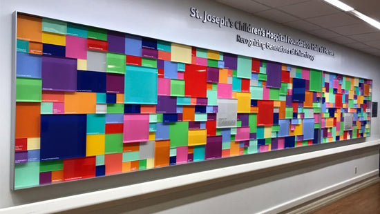 Colorful mosaic wall donor plaques in a hospital setting with 'St. Joseph's Children's Hospital' text.