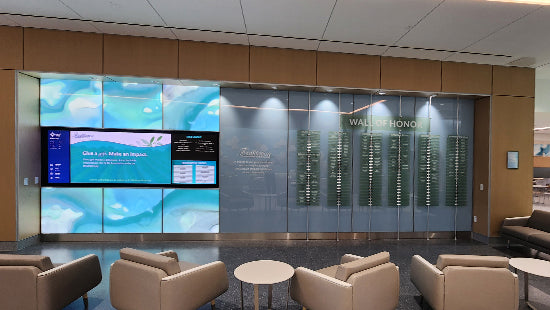 Wall of Honor donor acrylic recognition wall sign system behind a large glass door in a modern waiting room