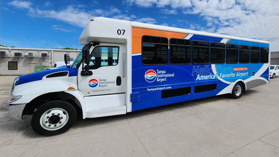 Bus with Tampa International Airport branding vehicle wrap on a clear day