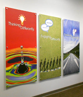 Three motivational posters on a wall with colorful designs and text.