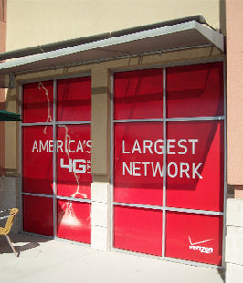 Red window graphic on glass door with 'America's Largest 4G Network' text and Verizon logo.