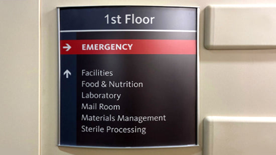 Vista Systems floor directory sign with emergency and various room labels on a wall.