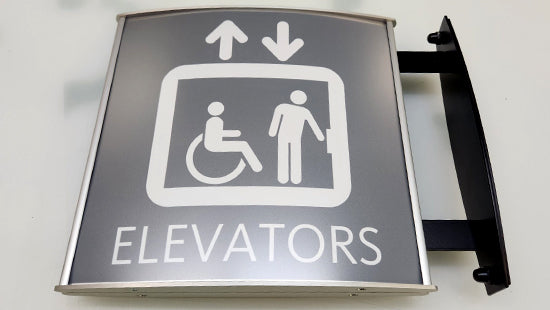 Vista Systems elevator sign with accessibility icons and wall bracket