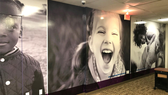 Wall mural with black and white photographs of children in a room setting