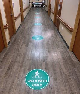 Hallway with wayfinding floor stickers indicating a walk path only