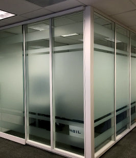 Glass office partitions with window film on an interior office space.